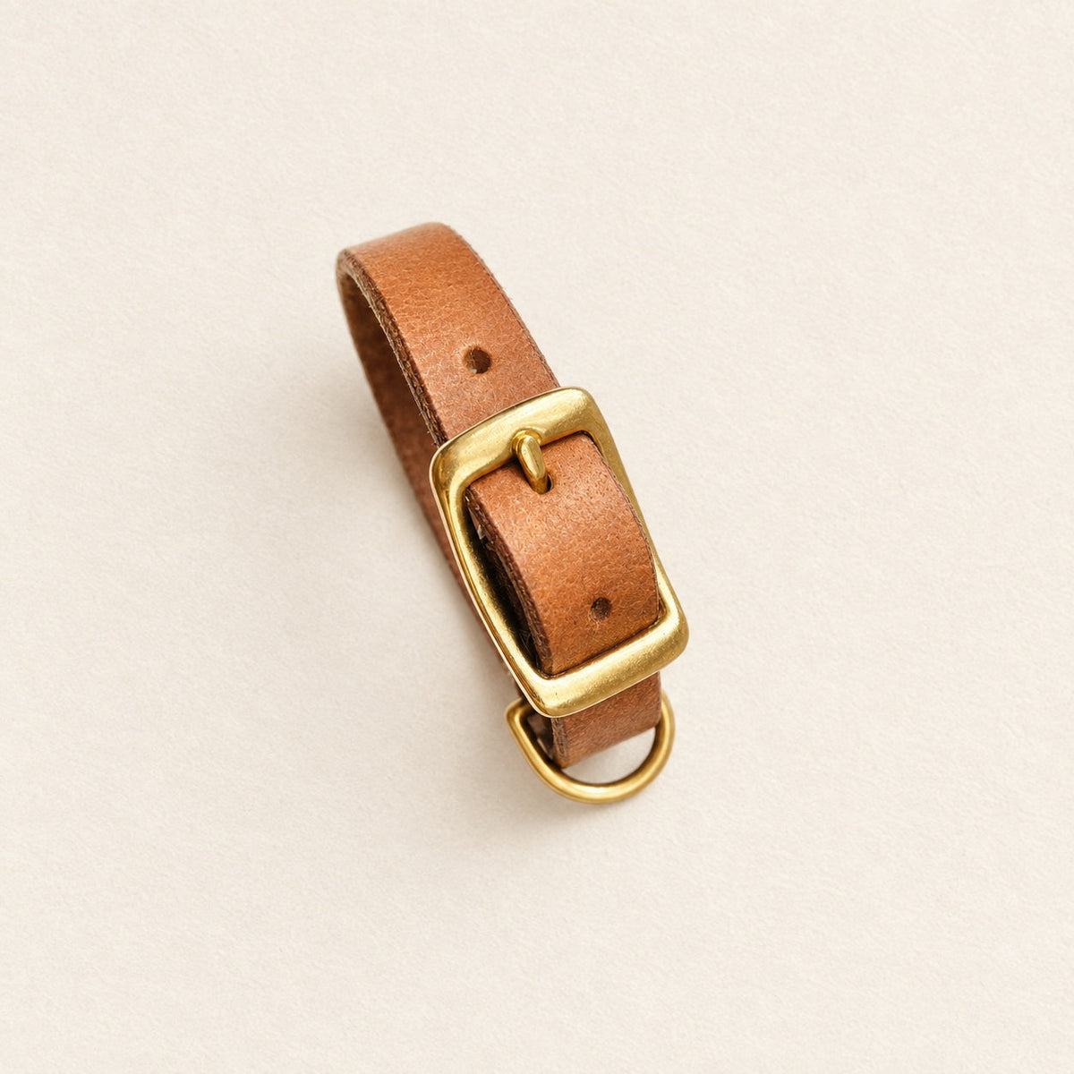 Collier en cuir sur fond crème studio